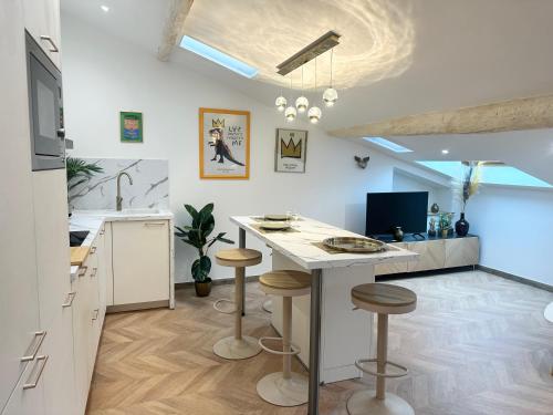 une cuisine avec une table et des tabourets dans une pièce dans l'établissement Elegant mansardé-place du pin, à Nice