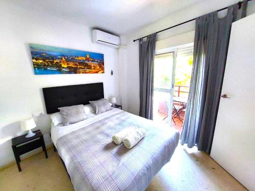 ein Schlafzimmer mit einem Bett mit zwei Handtüchern darauf in der Unterkunft Fray Isidoro Apartment in Sevilla