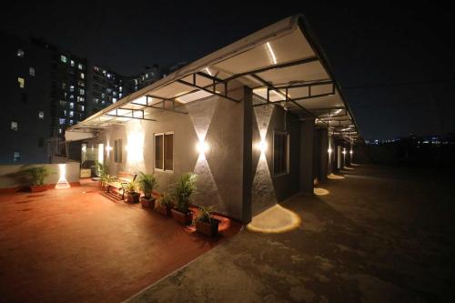 un bâtiment avec des plantes sur son côté la nuit dans l'établissement CABINSTAY-AIRPORT, à Mumbai