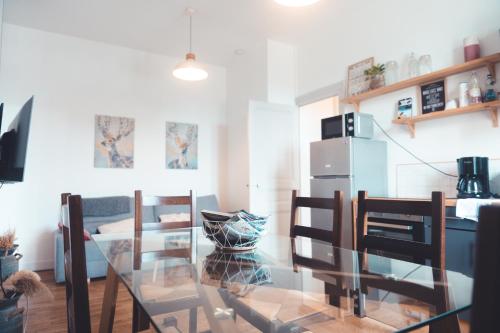 une salle à manger avec une table et des chaises en verre dans l'établissement Le Ronsardien - Appartement calme et confortable, à Tours