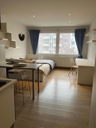 ein Schlafzimmer mit einem Bett und eine Küche mit einem Tisch in der Unterkunft Sint-Amandstraat A4 in Gent