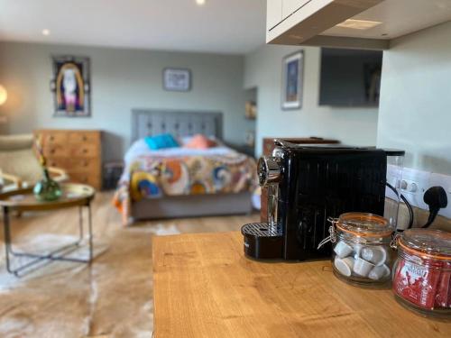 a kitchen with a coffee maker on a counter with a bed at Beautiful Retro Flat above Pub. in Shepton Mallet
