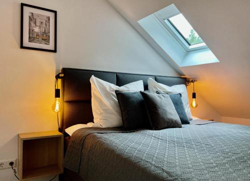 um quarto com uma cama com almofadas e uma janela em VonMos Loft Apartment em Bernkastel-Kues