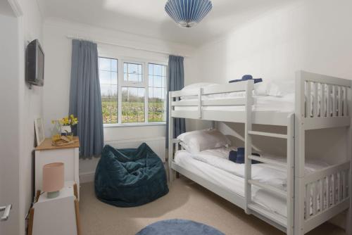 a bedroom with two bunk beds and a window at Westaway House in Port Isaac