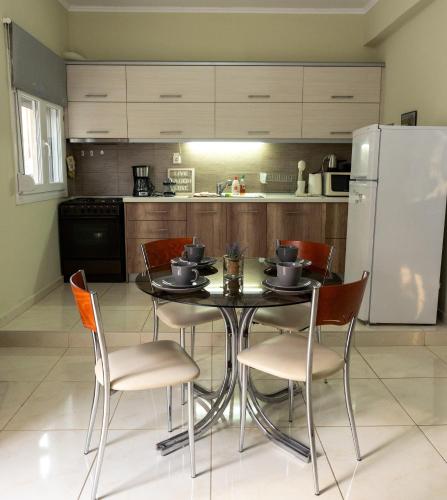 a kitchen with a table and chairs and a refrigerator at Dream House in Xanthi