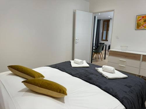 une chambre avec un grand lit avec des oreillers verts dans l'établissement Appart'hotel Le clos des voyageurs - BY PRIMO C0NCIERGERIE, à Sennecey-le-Grand