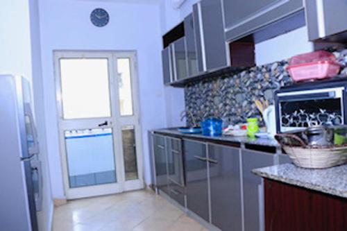 eine Küche mit einem Kühlschrank und einer Arbeitsplatte in der Unterkunft Very secure apartment Bole Addis Enyi Real Estate in Addis Abeba