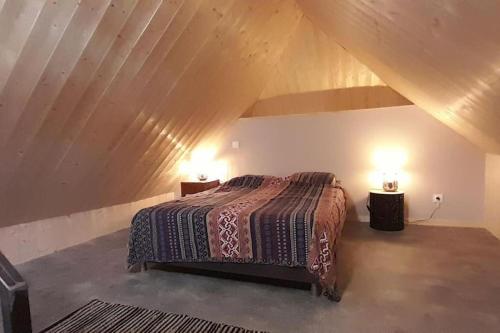 a bedroom with a bed in a attic with two lamps at LAMATACAM, T3, RDC, 2 chamb. centre Argelès Gazost in Argelès-Gazost