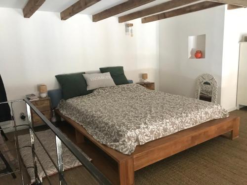 ein Schlafzimmer mit einem großen Bett mit grünen Kissen in der Unterkunft Appartement loft 60 m2 centre ville in Sète