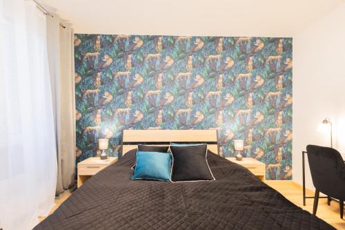 een slaapkamer met een groot bed met kleurrijk behang bij Glow Apartments, Apartament Luna Śródmieście in Gdańsk
