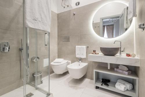 uma casa de banho com um WC, um lavatório e um espelho. em Lipari Suite B&B em Lipari