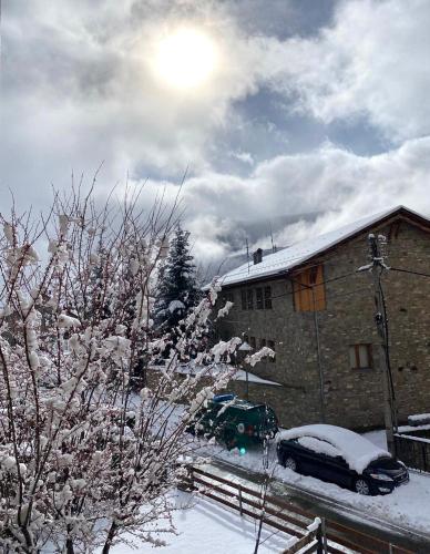 a house with a car parked in the snow at El Dúplex de Espot - L'Amfitriona in Espot
