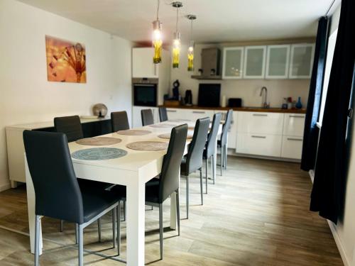 a kitchen and dining room with a white table and chairs at Ferienhaus Wachwitzgrund in Dresden