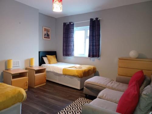 een kleine kamer met 2 bedden en een bank bij Luxury 3BR House - Free Parking and Stunning Garden! in Nottingham