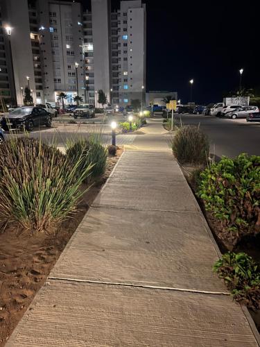 a sidewalk in the middle of a city at night at Vista Increíble en Laguna Del Mar piso 13 in La Serena