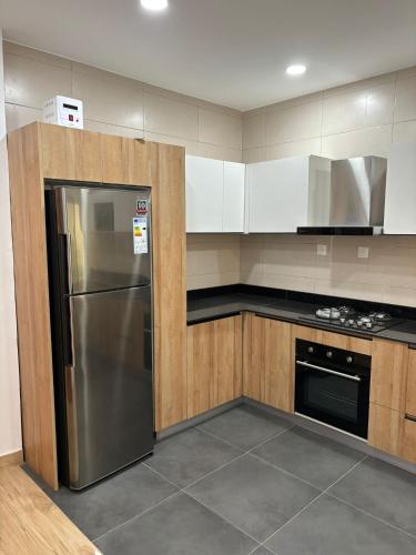 eine Küche mit einem Kühlschrank aus Edelstahl und Holzschränken in der Unterkunft Luxe villa in Cotonou
