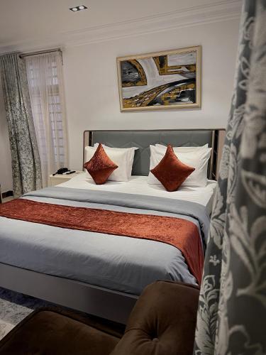 a bedroom with a large bed with red pillows at Glovis Luxury Suites in Abuja