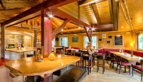 restauracja z drewnianymi sufitami, stołami i krzesłami w obiekcie Landhotel Grashof w mieście Mittelkalbach