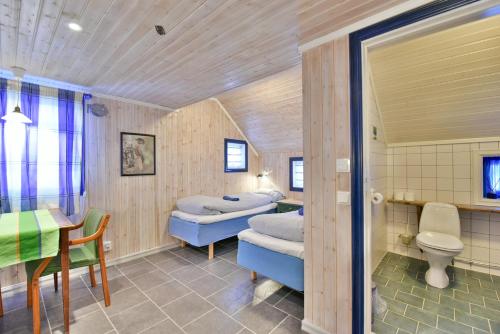 KongsfjordにあるKongsfjord Arctic Lodgeのベッド2台、テーブル、テーブル、椅子が備わる客室です。