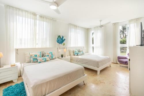 - 2 lits dans une chambre blanche avec fenêtres dans l'établissement Beach front and beach access at Nueva Romana, à Juan Dolio