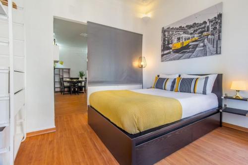 リスボンにあるParaíso Alfamaのベッドルーム1室(大型ベッド1台、黄色い毛布付)