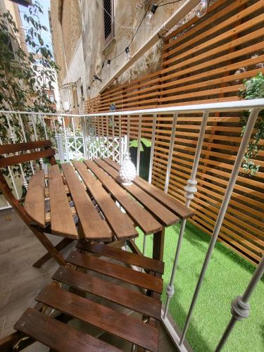a wooden table and chair on a balcony at Atrium in Castellammare del Golfo