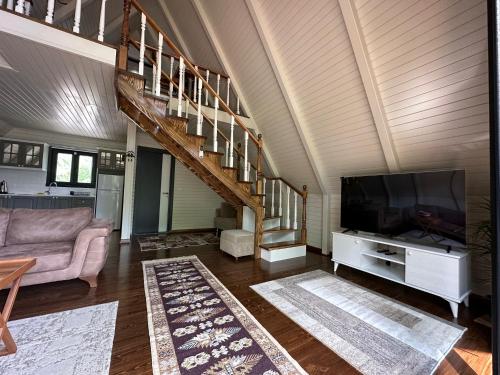 uma sala de estar com televisão e uma escadaria em Guzel Evler Family Resort em Sapanca