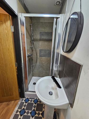 uma pequena casa de banho com um lavatório e um chuveiro em Double en suit room in Levenshulme (2) em Manchester