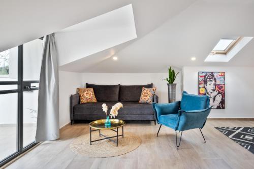 a living room with a couch and two chairs at Valley Suites in Luzit