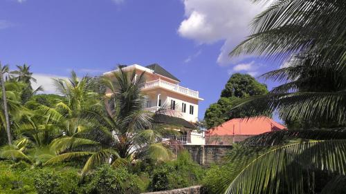 a white house with palm trees in front of it at Bamboo House BnB in Bondeni