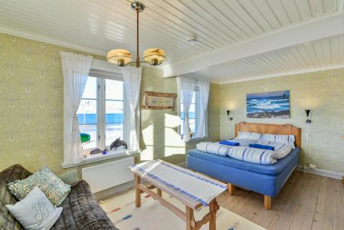 Kongsfjord Arctic Lodge في Kongsfjord: غرفة نوم بسرير واريكة وطاولة