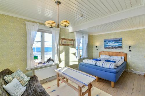 a bedroom with a bed and a couch and a table at Kongsfjord Arctic Lodge in Kongsfjord