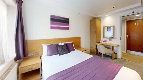 a hotel room with a bed and a desk at CIM Business Centre in Maidenhead