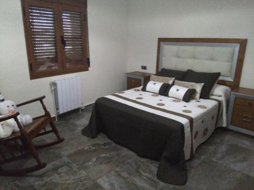 een slaapkamer met een groot bed en een teddybeer bij Rural Villa Garcia Molina Baza in Baza