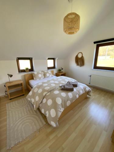 a bedroom with a bed and a wooden floor at La Cardamine in Marche-en-Famenne
