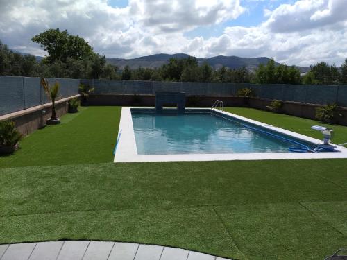 a swimming pool in a yard with green grass at Rural Villa Garcia Molina Baza in Baza