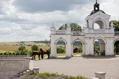 ein Pferd steht vor einem weißen Gebäude in der Unterkunft Edem Resort Medical & SPA in Strelki