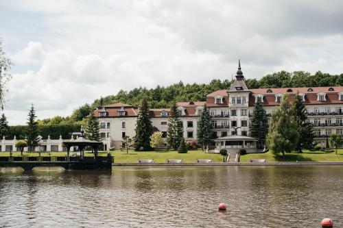 ein großes Gebäude neben einem Wasserkörper in der Unterkunft Edem Resort Medical & SPA in Strelki