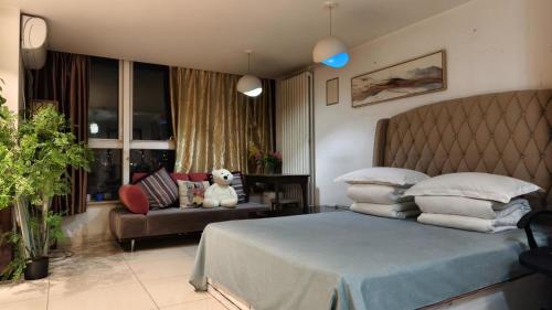 a bedroom with a bed and a couch at Chaoyang Joy City Hardcover Apartment in Beijing