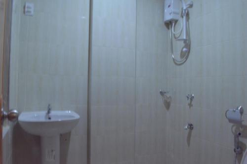 a bathroom with a shower and a sink at Manora Apartment in Talisay
