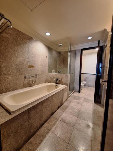 uma grande casa de banho com banheira e lavatório em Times Square Service Apartment , Kuala Lumpur em Kuala Lumpur