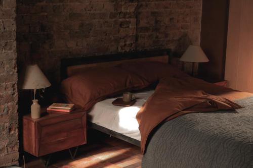 a bedroom with a bed and a nightstand with two lamps at Mid-Century Studio in London