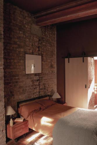 a bedroom with a bed and a brick wall at Mid-Century Studio in London
