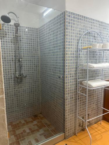 a bathroom with a shower with blue tiles at Villa bord de mer louis in Libreville