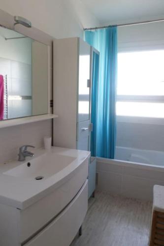 une salle de bain avec un lavabo, un miroir et une baignoire dans l'établissement T3 Tout confort-20 min à pied plage, à Fréjus