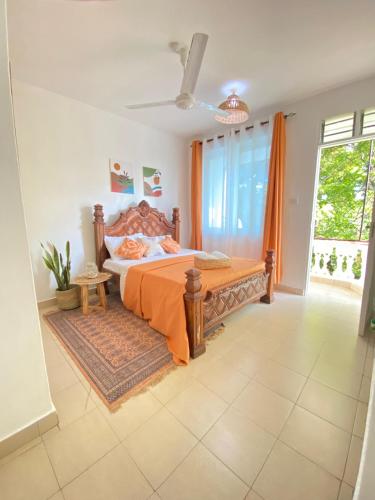 a bedroom with a bed and a large window at MASKANI COSY APARTMENT - Nyali, Mombasa. in Mombasa