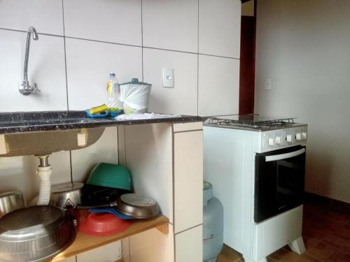 a small kitchen with a sink and a stove at Chales Horizonte das Pedras in São Thomé das Letras