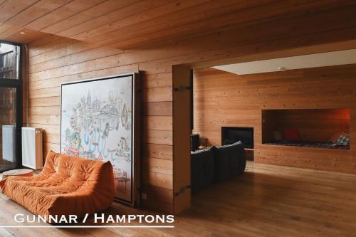 une chaise orange dans une chambre dotée de murs en bois dans l'établissement Domaine De L'Ardoisiere, à Alle