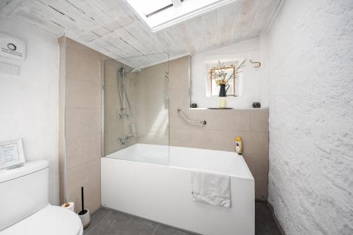 un bagno bianco con vasca e WC di Devlin's Cottage a Cape Bridgewater