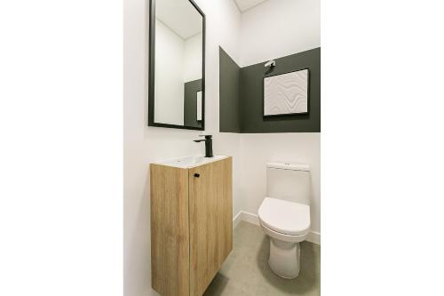 uma casa de banho com um WC, um lavatório e um espelho. em Apto incrível em Jurere Internacional - SRE505 em Florianópolis